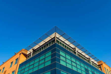 VICENZA, ITALY - 05/30/2020. Detail of a directional building in composite style. Large blue glass...