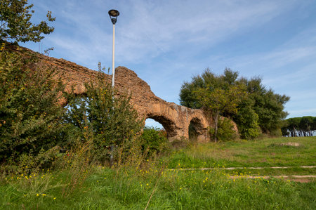 Alexandrian Aqueduct, the last of the great Roman aqueducts, built by the Emperor Alexander Severus. Detail of the arches and bricks on a sunny day and blue sky in the park, centocelle area. Romeの写真素材