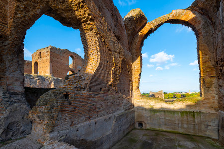 Ruins of the Imperial Villa dei Quintili, the thermal baths and the calidarium on the Via Appia in Rome, on a beautiful day of blue sky a suggestive architectural image of the brick building.の写真素材