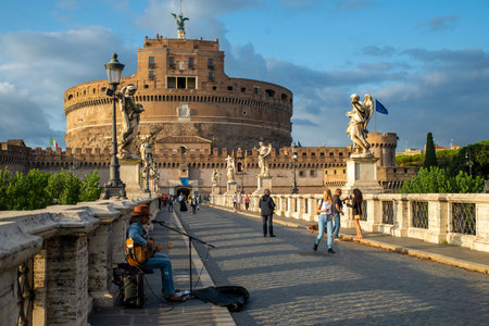 Front view of Castel Sant'Angelo, Mausoleo di Adriano, Vatican, from the Ponte degli Angeli over the Tiber, with a musician on an autumn day, blue sky after a thunderstorm, Vatican, Rome, Italy.のeditorial素材