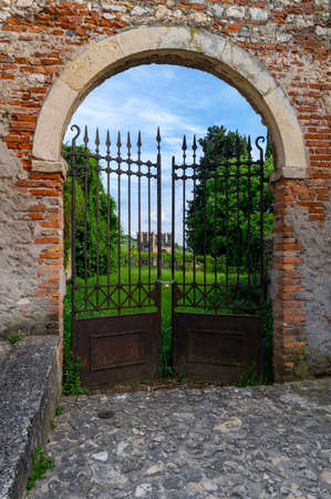 Ancient rusty iron gate, of the Soave castle, detail of the arched entrance in a part of the secret garden. Verona, Veneto Italy.のeditorial素材