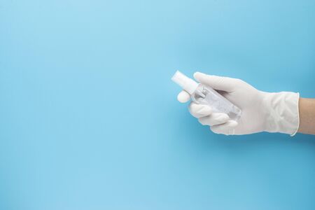 hand hold alcohol gel blue background protext covid-19