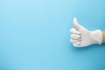 doctor put surgical gloves with blue background copy space for text