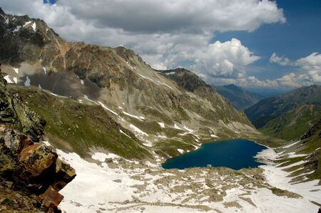 Large still lake in Caucasian mountains, shot from neighbour pass