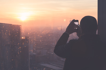 Man photographing the sunset from \ &#39;highの写真素材