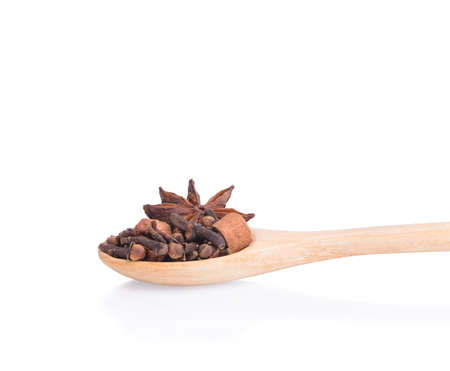 Spices: cloves and cinnamon sticks and anise in wooden spoon on white background.の写真素材