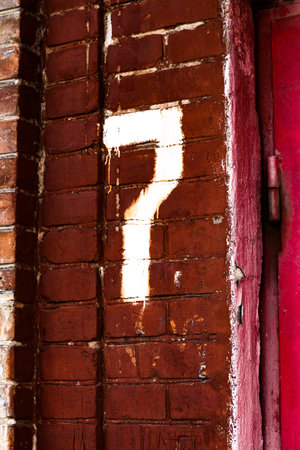 Number 7 seven on the red brick wall of the house.の写真素材