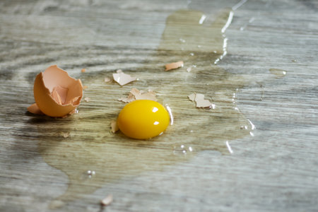 Broken egg on the floor with copy space Selective focus. This photo can be used for the concept of...