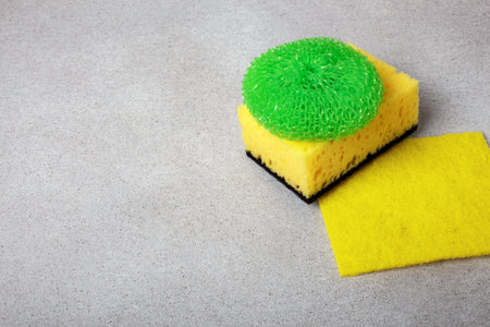 multi-colored different tips of dishwashing sponges and napkins on gray background. The topic of...