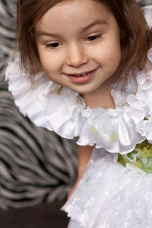 little cute girl in white dress with a tiara on her headの写真素材
