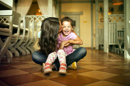 Mum with a daughter sit on a floor の写真素材