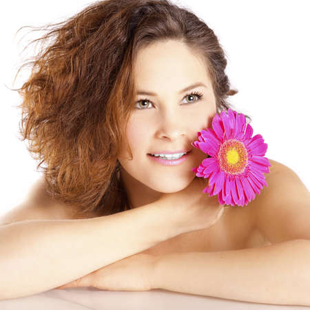 Girl with a flower on a white background in the studioの写真素材