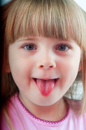a little girl in a pink shirt posing in studio