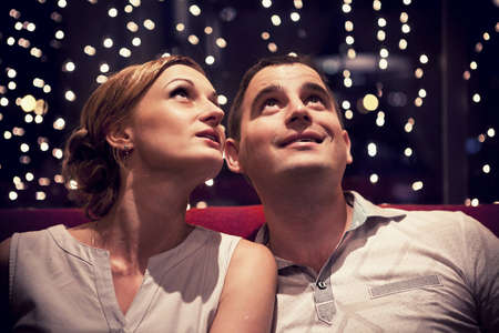 young couple sitting on a red couch