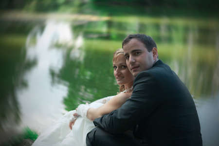 young couple sitting by the riverの写真素材