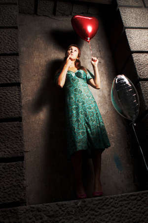 young woman holding a ball in the form of heartの写真素材