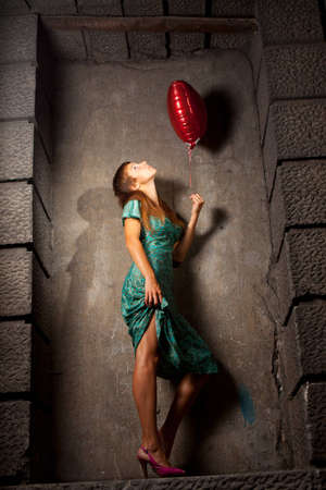 young woman holding a ball in the form of heartの写真素材