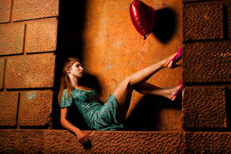 young woman holding a ball in the form of heartの写真素材