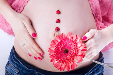 pregnant woman's belly decorated with flowersの写真素材