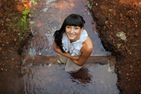 young woman standing in water looking upの写真素材