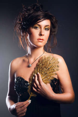 young girl holding an ornament of gold feathers