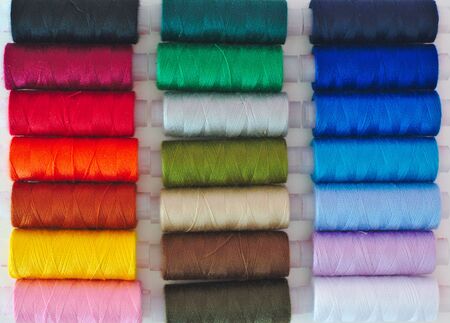 Colored thread spools close up background