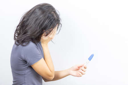 Girl with pregnancy test on white background