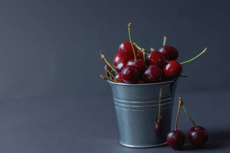 cherry in a bucket on a dark background, fruit season