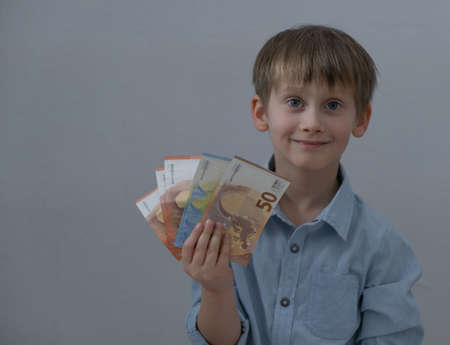 The boy looks at the money in his hands.の写真素材