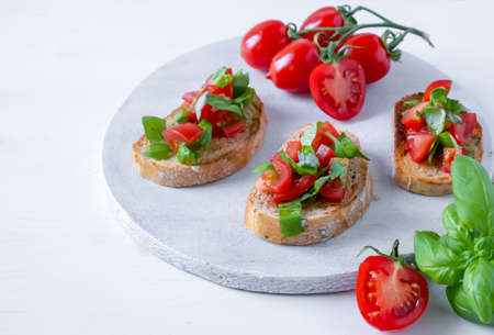 bruschetta with tomatoes and basil on fried in olive oil rye baguetteの写真素材