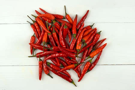 Red chilli pepper in the tray on a white table. View from above.
