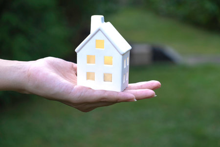 House model in female hand on a green blurred backgroundの写真素材