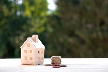 Model of the house on the background of nature, next to the moneyの写真素材