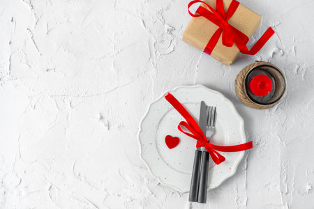 Festive table setting for Valentines Day with fork, knife and hearts. Top view.の写真素材