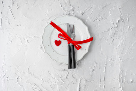 Festive table setting for Valentines Day with fork, knife and hearts. Top view.の写真素材