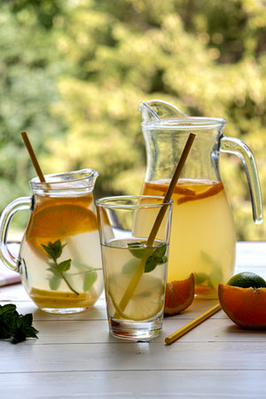 Preparation of lemonade drink. Lemonade in a jug and lemon and lime and mintの写真素材
