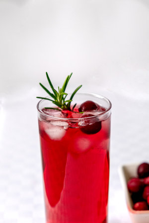 Cranberry juice in a glass on a table with a white tableclothの写真素材
