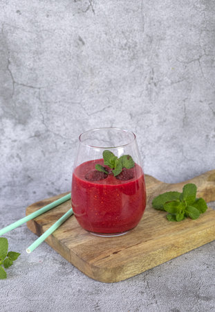 Raspberry smoothie garnished with fresh fruit and mint. vertical photoの写真素材