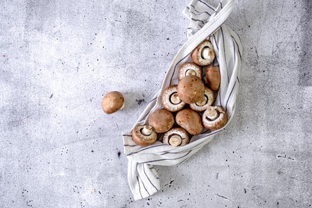 Brown champignons in a kitchen towel on the tableの写真素材