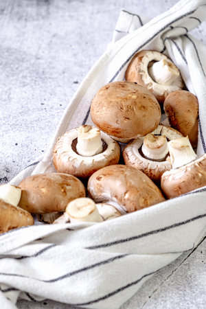 Brown champignons in a kitchen towel on the tableの写真素材