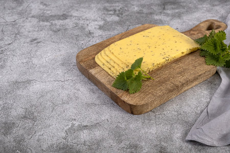 Dutch cheese with nettles on a wooden boardの写真素材