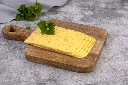 Piece of Dutch Gouda nettle cheese and slicesの写真素材
