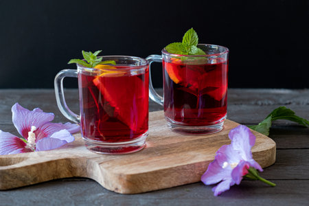 Red Hot Hibiscus tea in a glass mug on a wooden tableの写真素材