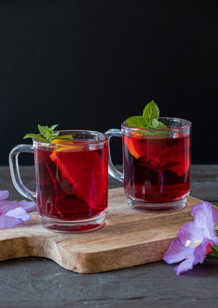 Red Hot Hibiscus tea in a glass mug on a wooden table, vertical photoの写真素材
