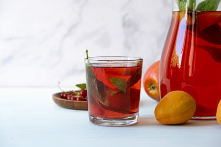 Fruit drink. Jug with a drink made from berries, apricots and apples. Refreshing summer berry drink.