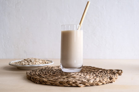 Oat milk in a glass on the tableの写真素材