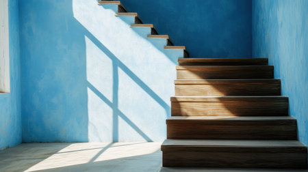 Calm stairway scene with daylight washing over wood stairs and blue paintの素材