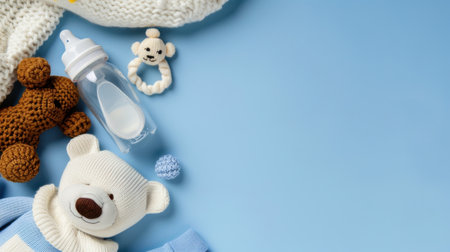 A charming arrangement of baby accessories including soft toys, a baby bottle, and knitted items, all set against a soothing light blue background, ideal for nursery decor.の素材