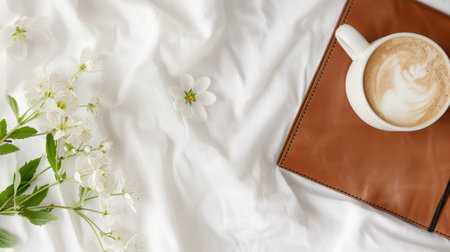 A serene morning scene featuring a cup of coffee, a leather notebook, and delicate flowers on soft white linen, perfect for inspiring relaxation and creativity.の素材