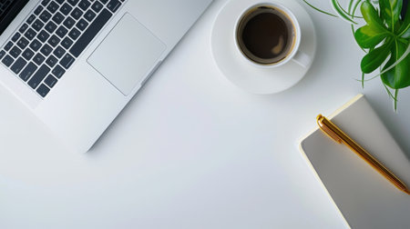 A stylish and minimalist workspace featuring a laptop, coffee cup, notebook with pen, and a green plant on a white desk, perfect for inspiration and productivity.の素材